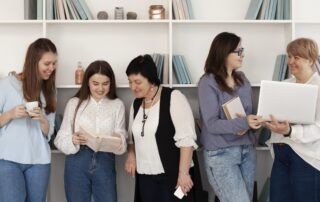 Women reading, discussing ideas, and working together in a supportive space that encourages women’s mental health and workplace well-being.
